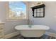 The main bathroom features a free standing tub with chrome fixtures and a large picture window at 114 Rock Creek Ln, Canton, GA 30114