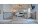 Spacious main bedroom featuring a tray ceiling, ceiling fan, platform with decorative railings, and French doors at 114 Rock Creek Ln, Canton, GA 30114