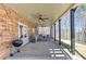 Relaxing covered patio with a ceiling fan, stone accent wall, and outdoor furniture at 114 Rock Creek Ln, Canton, GA 30114