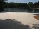 Scenic sandy beach with a lake and lush trees in the background, perfect for relaxation at 2401 Northlake Ct, Atlanta, GA 30345