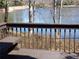 View from the wood deck with a brown wood rail and wrought iron fence overlooking the lake at 2401 Northlake Ct, Atlanta, GA 30345