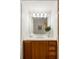 Bathroom vanity with wood cabinets, drawers, solid surface counters, mirror, and stylish light fixture at 2881 Peachtree Ne Rd # 702, Atlanta, GA 30305