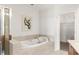 Elegant bathroom featuring a soaking tub with stone surround and a glass-enclosed shower at 2881 Peachtree Ne Rd # 702, Atlanta, GA 30305