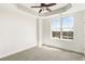 Bright bedroom with a large window offering exterior views and tray ceiling with ceiling fan at 2881 Peachtree Ne Rd # 702, Atlanta, GA 30305