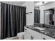 Modern bathroom features a granite countertop vanity and a dark shower curtain at 3324 Peachtree Ne Rd # 1115, Atlanta, GA 30326