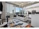 Bright open-concept living area featuring hardwood floors, modern furnishings, and a city view through large windows at 3324 Peachtree Ne Rd # 1115, Atlanta, GA 30326