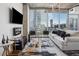 Contemporary living room featuring an electric fireplace, large windows, and views of the city skyline at 3324 Peachtree Ne Rd # 1115, Atlanta, GA 30326