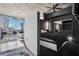 Modern bedroom featuring a bed with black bedding, and separation wall open to the living room with cityscape views at 3324 Peachtree Ne Rd # 1115, Atlanta, GA 30326