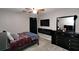 Comfortable bedroom with an electric fireplace, mounted TV, and stylish dark furniture at 67 Mossy Oak Ln, Dallas, GA 30157