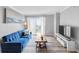 Bright living room with a comfy blue sofa, decorative rug, and sliding glass doors to a balcony at 795 Hammond Dr # 1405, Atlanta, GA 30328