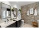 Bright bathroom featuring double sink vanities, decorative mirrors, and a brick accent wall at 1354 Fernwood Ne Cir, Brookhaven, GA 30319