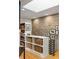 Hallway with built-in shelves, a skylight, and brick accent wall at 1354 Fernwood Ne Cir, Brookhaven, GA 30319