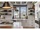 Modern kitchen features white cabinetry, floating shelves, and a large window overlooking a charming neighborhood at 1354 Fernwood Ne Cir, Brookhaven, GA 30319