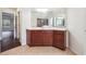Bathroom vanity with wood cabinets, a white countertop, and views of the shower and tub in the mirror at 5932 Vinings Vintage Way, Mableton, GA 30126