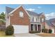 Charming two-story home with a brick facade, a well-manicured lawn, and an attached two-car garage at 5932 Vinings Vintage Way, Mableton, GA 30126