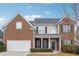 Charming two-story home with a brick facade, a well-manicured lawn, and an attached two-car garage at 5932 Vinings Vintage Way, Mableton, GA 30126