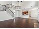 Bright living room featuring hardwood floors, staircase with iron spindles, and an open-concept kitchen at 5932 Vinings Vintage Way, Mableton, GA 30126