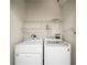 Functional laundry room with white washer, dryer, and shelving for organized storage at 943 Peachtree Ne St # 1108, Atlanta, GA 30309