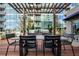 Inviting outdoor patio area with wood pergola, dining table, and views of the complex at 943 Peachtree Ne St # 1108, Atlanta, GA 30309