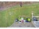 Aerial view of the back of a brick home with a spacious green backyard, patio and stylish outdoor furniture at 10166 Benton Woods Dr, Covington, GA 30014