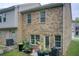 Exterior view of a brick home with a door leading to a patio that has green plants and outdoor furniture at 10166 Benton Woods Dr, Covington, GA 30014