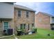 Townhome backyard with brick facade, landscaping, and a lush lawn at 10166 Benton Woods Dr, Covington, GA 30014