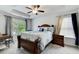 Well-lit bedroom with a tray ceiling, neutral decor, and comfortable carpet flooring at 10166 Benton Woods Dr, Covington, GA 30014