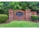 A stone sign that reads Benton Woods is framed by green bushes in front of a neighborhood entrance at 10166 Benton Woods Dr, Covington, GA 30014
