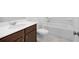 Bathroom features a dark wood vanity with a white countertop, toilet, and a white tub with shower at 1420 Windance Lake Dr, Loganville, GA 30052