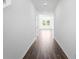 An inviting hallway has hardwood floors that lead to a bright open area with a view of the outdoors at 1420 Windance Lake Dr, Loganville, GA 30052