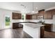 Modern kitchen with dark wood cabinets, stainless steel appliances, an island and backyard views at 1420 Windance Lake Dr, Loganville, GA 30052