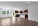 Open living area with hardwood floors featuring a kitchen with granite countertops, stainless appliances, and white cabinets at 1420 Windance Lake Dr, Loganville, GA 30052