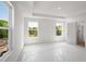 Light-filled bedroom featuring a tray ceiling, three windows, and an ensuite bathroom at 1420 Windance Lake Dr, Loganville, GA 30052