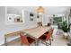 Bright dining room featuring a rustic wooden table and bench, with view to kitchen and outside access at 3465 Callie Still Rd, Lawrenceville, GA 30045