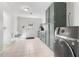 Bright laundry room with gray cabinets, white tile floor, and modern washer and dryer at 1060 Mclinden Se Ave, Smyrna, GA 30080