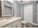 Neat bathroom featuring a vanity with sink, framed mirror and a white toilet at 200 River Vista Dr # 205, Atlanta, GA 30339
