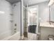 Clean bathroom with white tiled tub and vanity with view to a room beyond at 200 River Vista Dr # 205, Atlanta, GA 30339