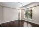A simple bedroom featuring dark wood floors and a window with blinds for natural light at 200 River Vista Dr # 205, Atlanta, GA 30339