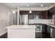 Modern kitchen features stainless steel appliances, dark wood cabinets, and a center island with marble countertops at 200 River Vista Dr # 205, Atlanta, GA 30339