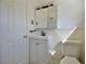 A full bathroom featuring a pedestal sink with storage, a mirrored medicine cabinet, and a door with a gold handle at 2422 Clarissa Nw Dr, Atlanta, GA 30318