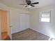 Bedroom features a closet with sliding doors, a ceiling fan, natural light, and vinyl flooring; door leads to ensuite bathroom at 2422 Clarissa Nw Dr, Atlanta, GA 30318