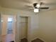 Cozy bedroom features a closet with sliding doors, a ceiling fan, and vinyl flooring; door leads to ensuite bathroom at 2422 Clarissa Nw Dr, Atlanta, GA 30318