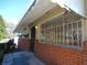 Close up of brick-lined porch with awning and security bars on the home's front window at 2422 Clarissa Nw Dr, Atlanta, GA 30318