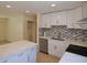 Renovated kitchen featuring white cabinets, tile backsplash, and stainless steel appliances at 2422 Clarissa Nw Dr, Atlanta, GA 30318