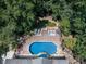 Aerial view of the pool with an entertainment deck surrounded by mature trees for privacy and shade at 1012 Jubilee Way, Powder Springs, GA 30127