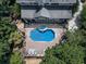 Aerial view of backyard featuring a sparkling pool, spa, and entertainment deck surrounded by lush greenery at 1012 Jubilee Way, Powder Springs, GA 30127