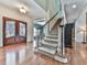 Foyer with decorative glass front door, staircase with carpet runner, and wood floors at 1012 Jubilee Way, Powder Springs, GA 30127