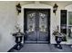 Elegant double front door with iron detailing, flanked by decorative planters and sconce lighting at 1012 Jubilee Way, Powder Springs, GA 30127