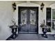 Elegant front door with iron detailing and decorative planters, enhancing curb appeal and creating a grand entrance at 1012 Jubilee Way, Powder Springs, GA 30127