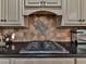 Close up of a kitchen with black granite countertop and backsplash with cabinets at 1012 Jubilee Way, Powder Springs, GA 30127